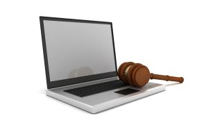 Gavel lies atop open laptop computer